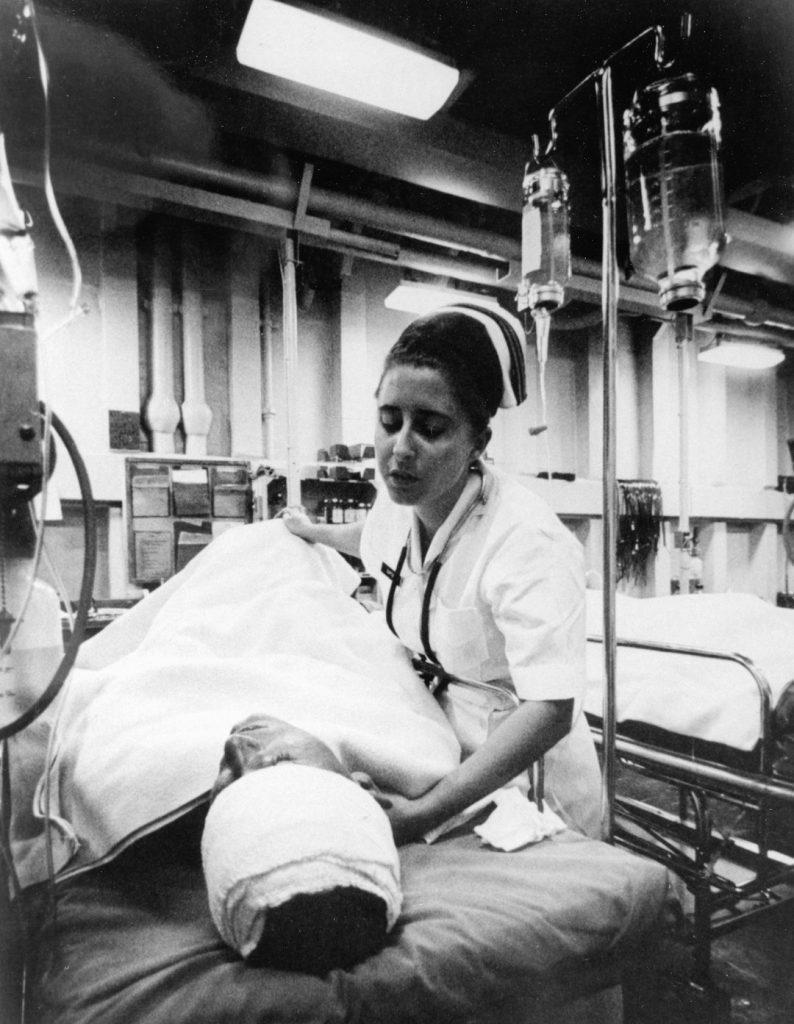 15-3001-1043 South China Sea: A nurse tends a patient just out of surgery in the intensive care ward of the hospital ship USS Repose (AH-16). [Nurse][Female][Patient][Vietnam War][Ward][Equipment and Supplies] Womens Vietnam Veterans Memorial Dedicated by David Klubes, Navy Medicine, BUMED, Washington, DC Navy Medicine Magazine November-Dececember 1993.